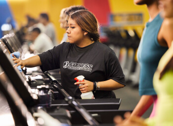 Women cleaning gym equipment